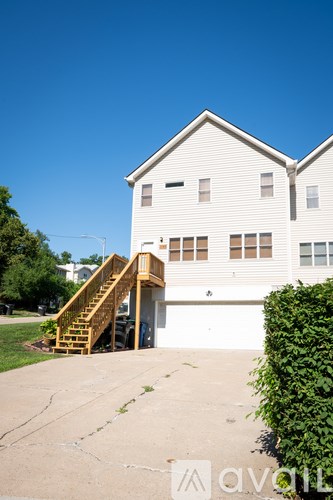 A white house with a wooden staircase leading to the garage.