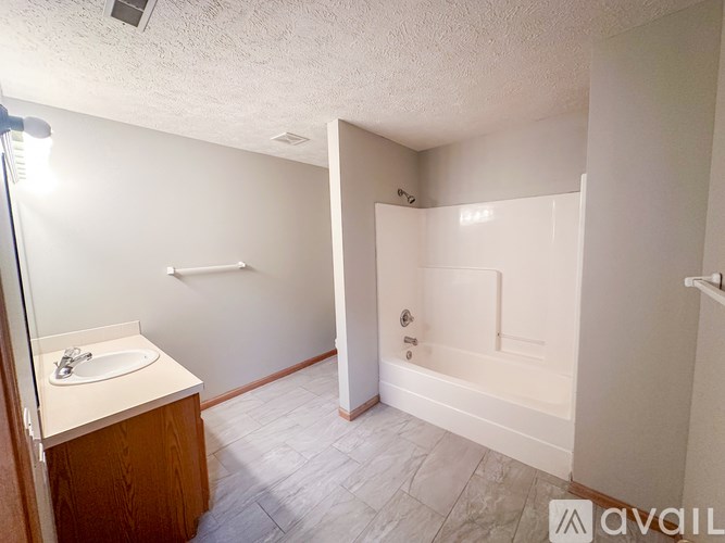 A bathroom with a sink, mirror, and bathtub.