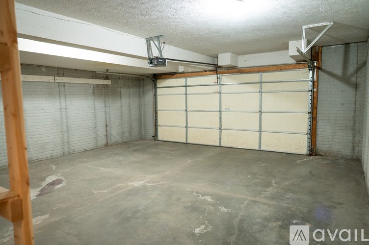 A large, empty garage with a white door and a concrete floor.