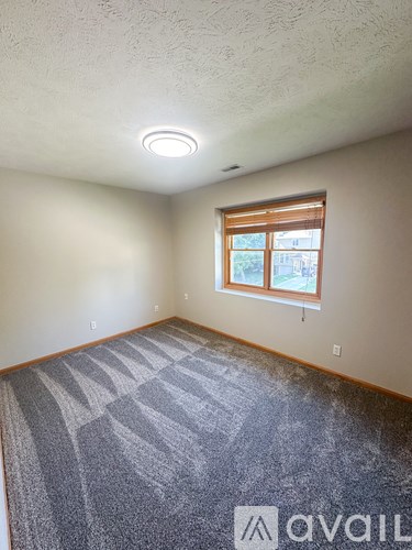A room with a carpeted floor and a window.