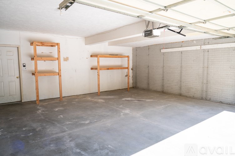 A room with a white door and a grey wall with a white ceiling and a white floor.