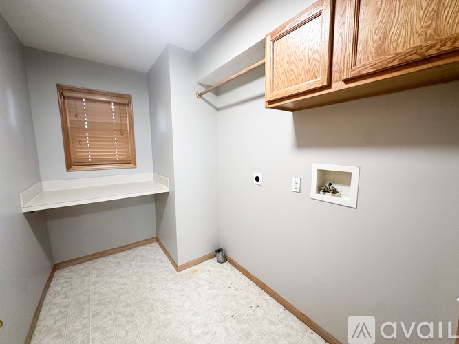 A small room with a window and a shelf.