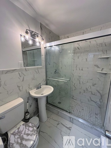 A bathroom with a toilet, sink, and shower.
