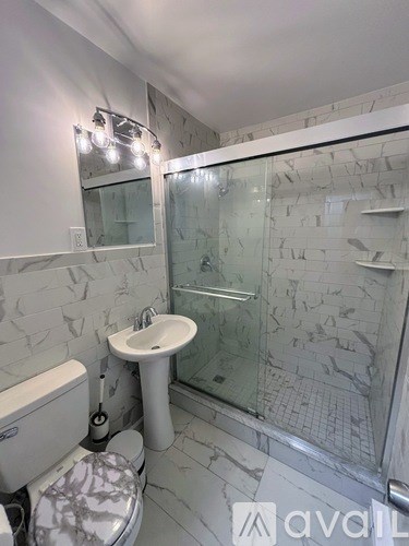 A bathroom with a toilet, sink, and shower.
