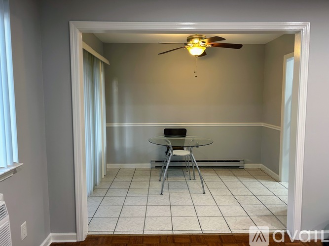 A room with a table and chairs and a ceiling fan.
