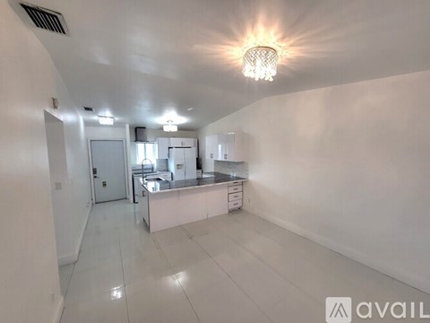 A spacious kitchen with white cabinets and a central island.