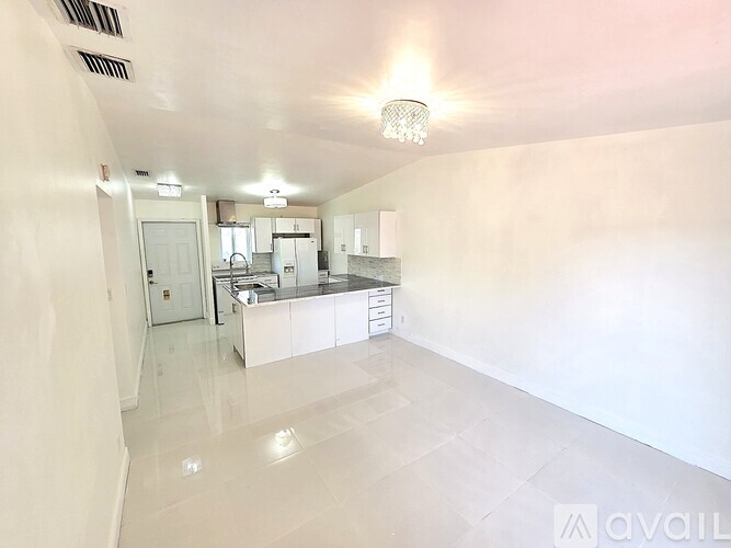 A modern kitchen with white cabinets and a large island.