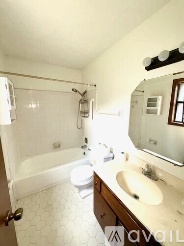 A white bathroom with a toilet, sink, and bathtub.
