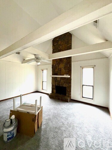 A room with a fireplace and a ceiling fan.