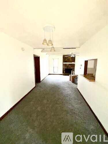 A long hallway with a fan and lights on the ceiling.