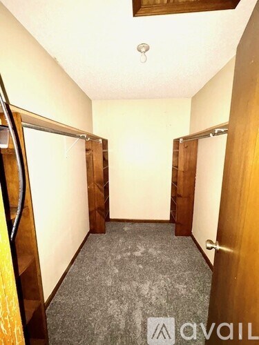 A hallway with a carpeted floor and two doors on either side.