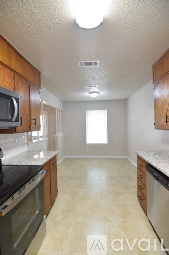 A kitchen with wooden cabinets and a black counter top.