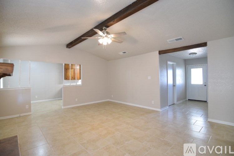 A spacious room with a ceiling fan and tiled flooring.