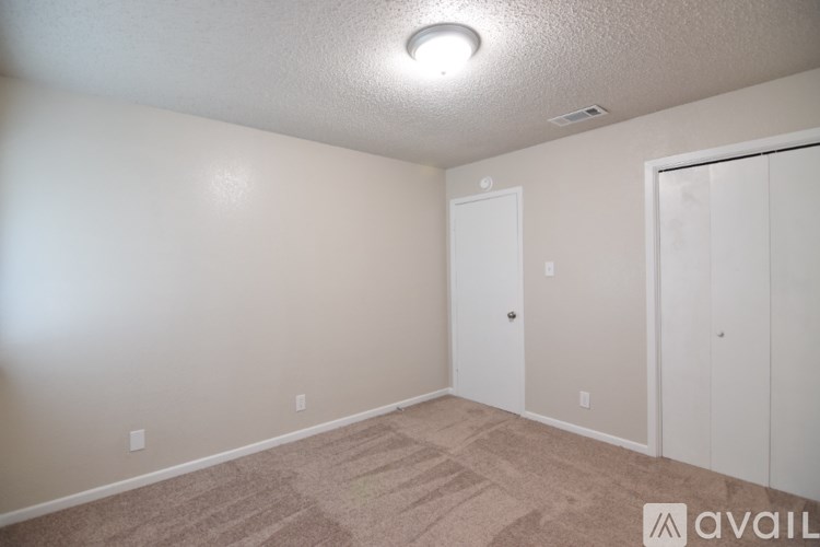 A room with a carpeted floor and a white door.