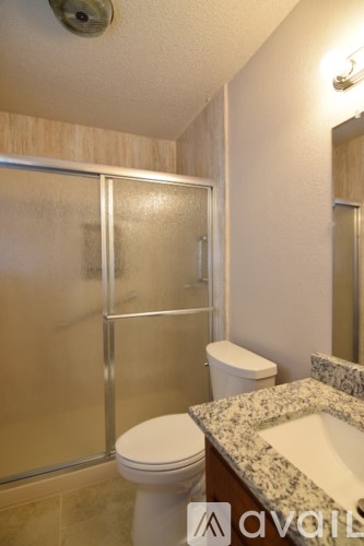 A bathroom with a toilet, sink and shower.