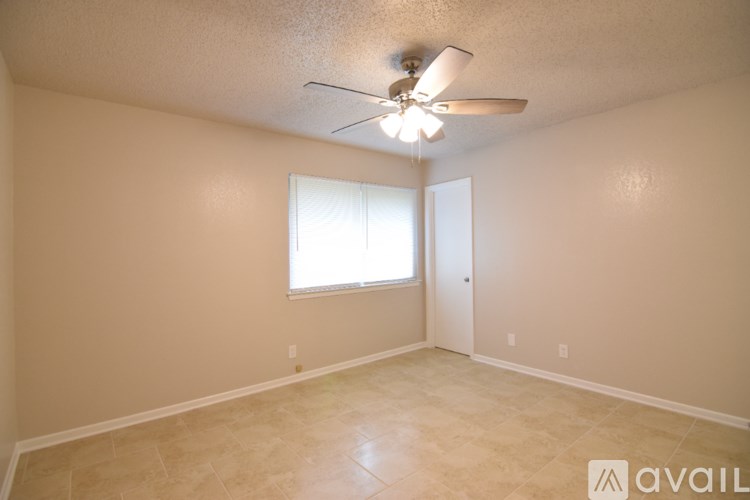 A room with a ceiling fan and a window.
