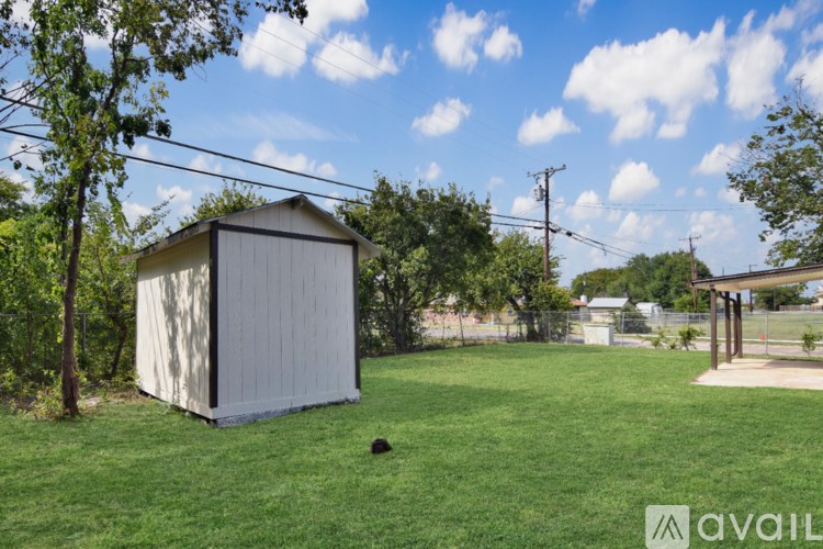 A shed sits in a grassy yard.