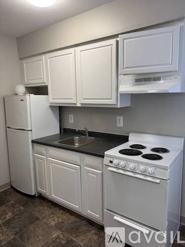A kitchen with white cabinets and a white stove.