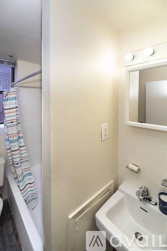 A white bathroom with a tub and a mirror.
