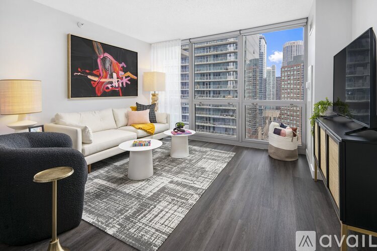 A living room with a large painting on the wall and a view of the city through the windows.