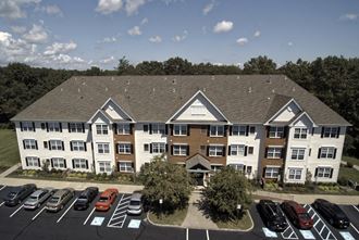 an aerial view of an apartment building with a parking lot