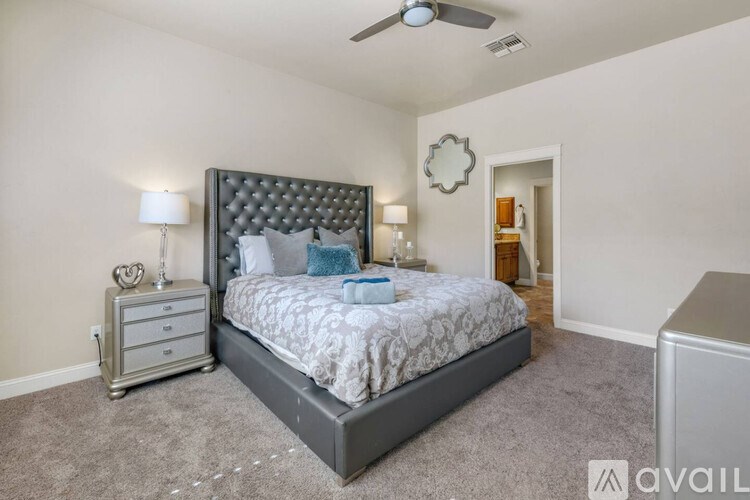 A bedroom with a large bed and a ceiling fan.