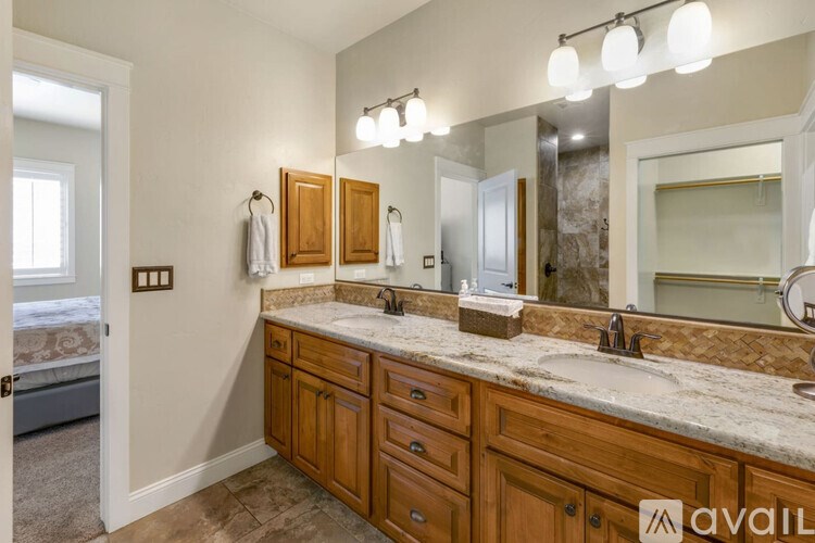 A bathroom with a vanity, two sinks, and a large mirror.