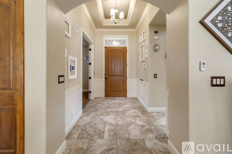 A hallway with a wooden door and tiled floor.