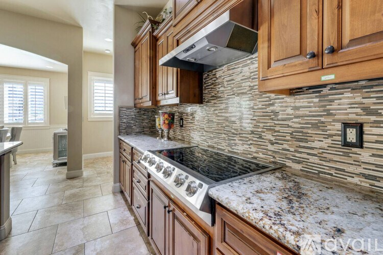 A kitchen with wooden cabinets and a granite countertop.