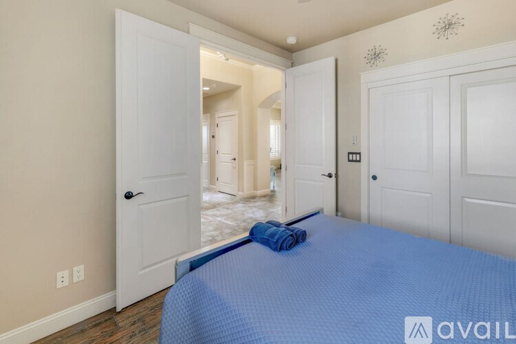 A bedroom with a blue bedspread and a white door.
