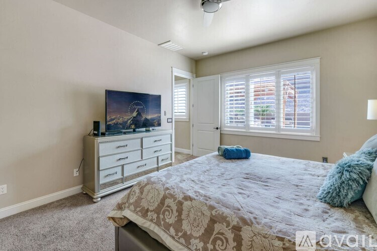 A bedroom with a bed, dresser, and window.