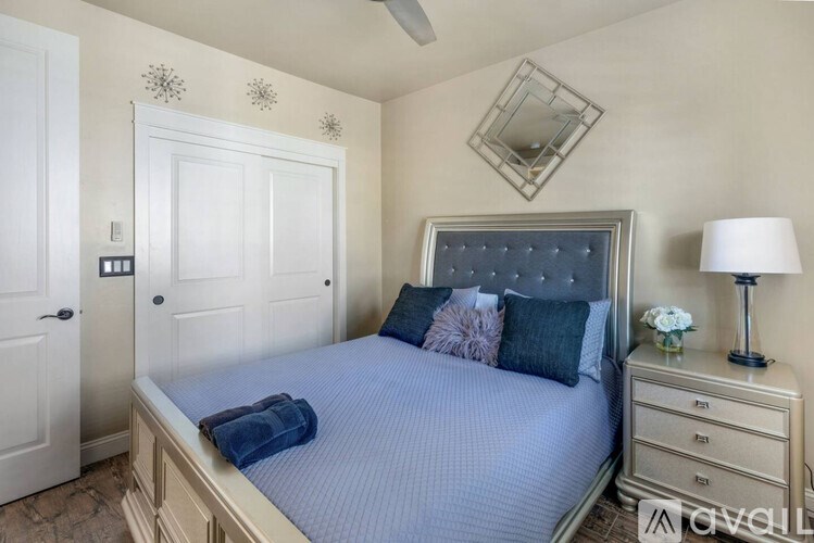 A bedroom with a bed, nightstand, and a ceiling fan.