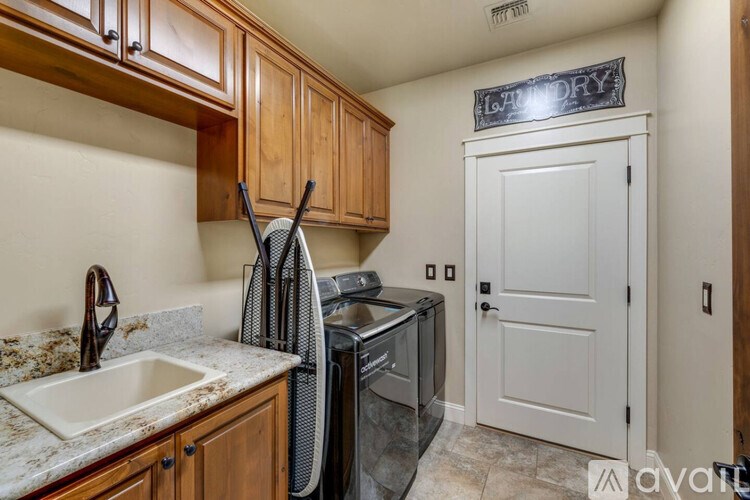 A kitchen with a sink, a washing machine, and a dryer.