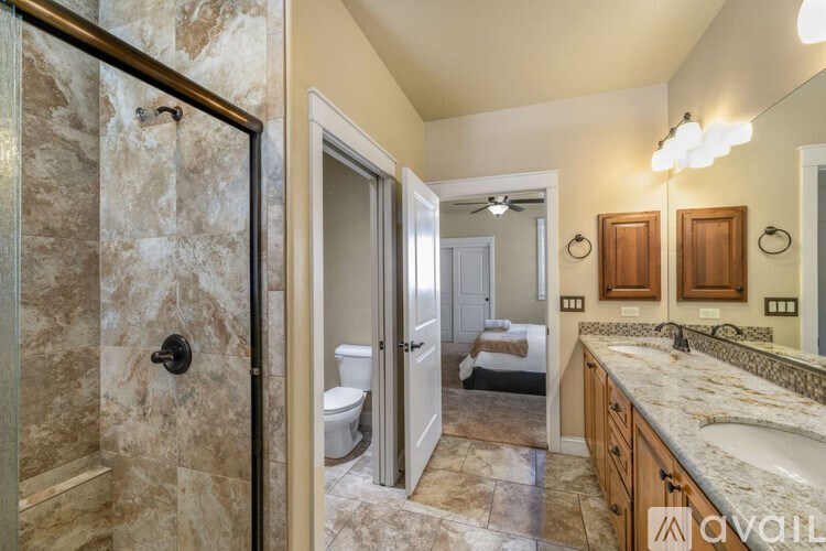A bathroom with a marble shower and a marble countertop.