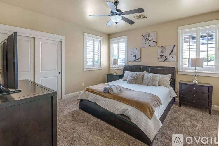 A bedroom with a bed, dresser, and television.