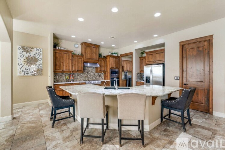 A kitchen with a table and chairs in the foreground and cabinets in the background.