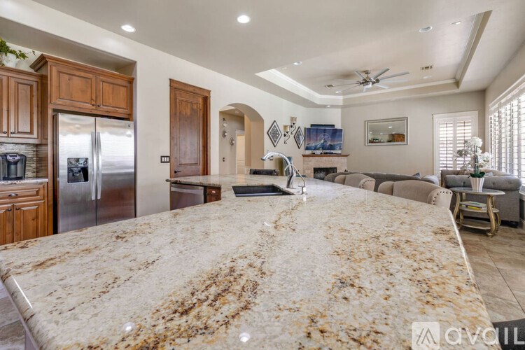 A kitchen with a granite countertop and stainless steel appliances.