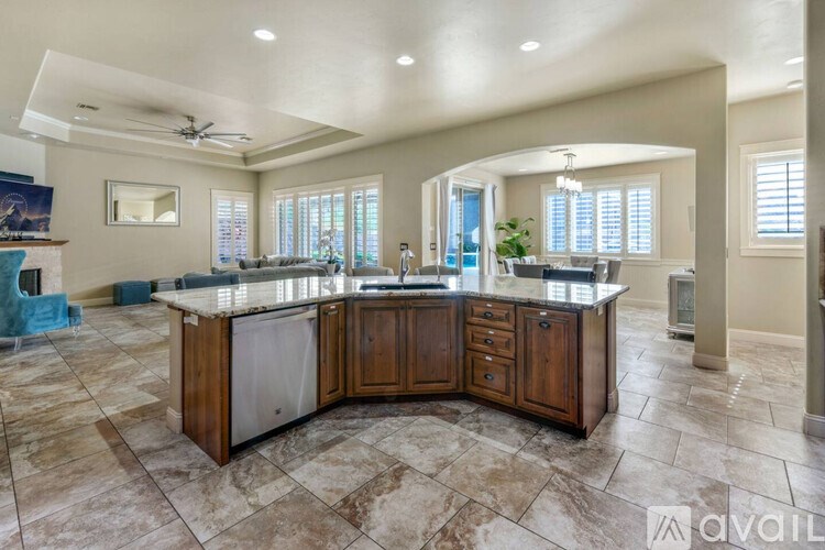 A kitchen with a large island and a ceiling fan.