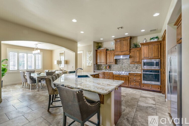 A kitchen with a marble countertop and wooden cabinets.
