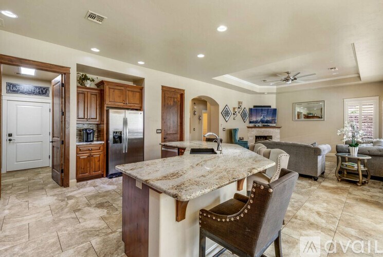 A kitchen with a marble countertop and a refrigerator with a stainless steel finish.