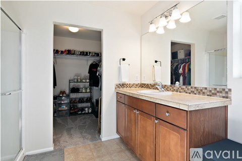 A bathroom with a sink, mirror, and wooden cabinets.