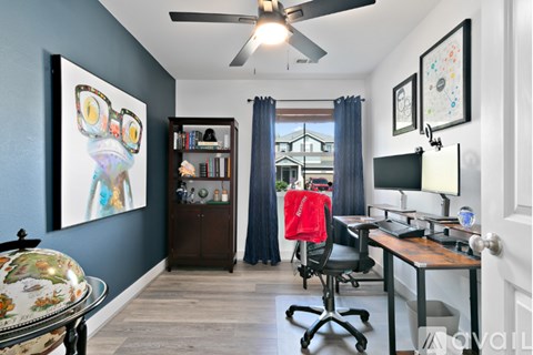 A room with a desk, chair, and bookshelf.