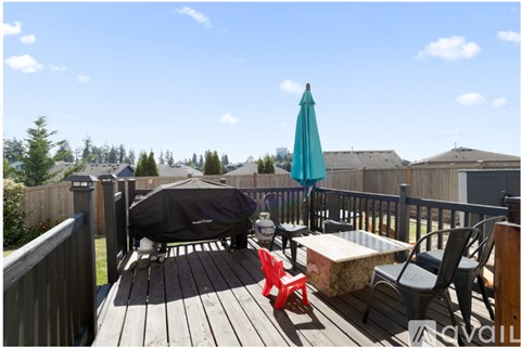 A deck with a table, chairs, and an umbrella.