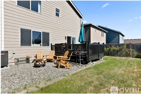 A patio area with chairs and a table outside a house.