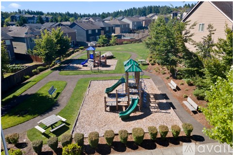 A playground with a green slide and a blue umbrella in a residential area.