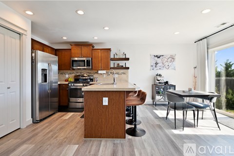 A kitchen with a wooden island and stainless steel appliances.