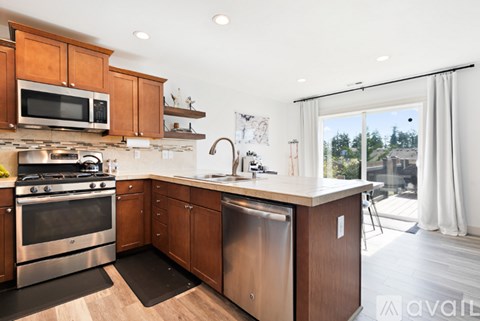 A modern kitchen with wooden cabinets and stainless steel appliances.