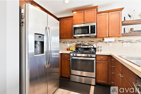 A kitchen with a stainless steel refrigerator, microwave, and oven.
