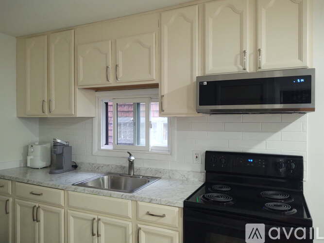 A kitchen with a black microwave above the stove.