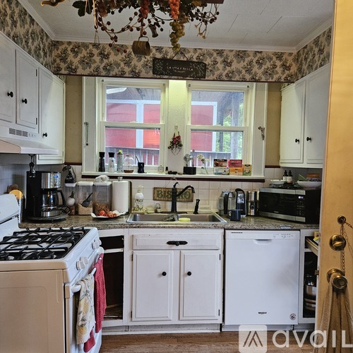 A kitchen with a white washing machine and a black stove top.
